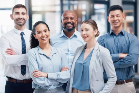 Photo d'une équipe de professionnels IT souriants, représentant l'équipe de DTSinfo dédiée à l'optimisation des infrastructures informatiques.